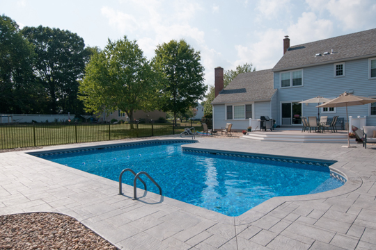 This is a photo of the true-L roman inground swimming pool with black fence installed by julianos
